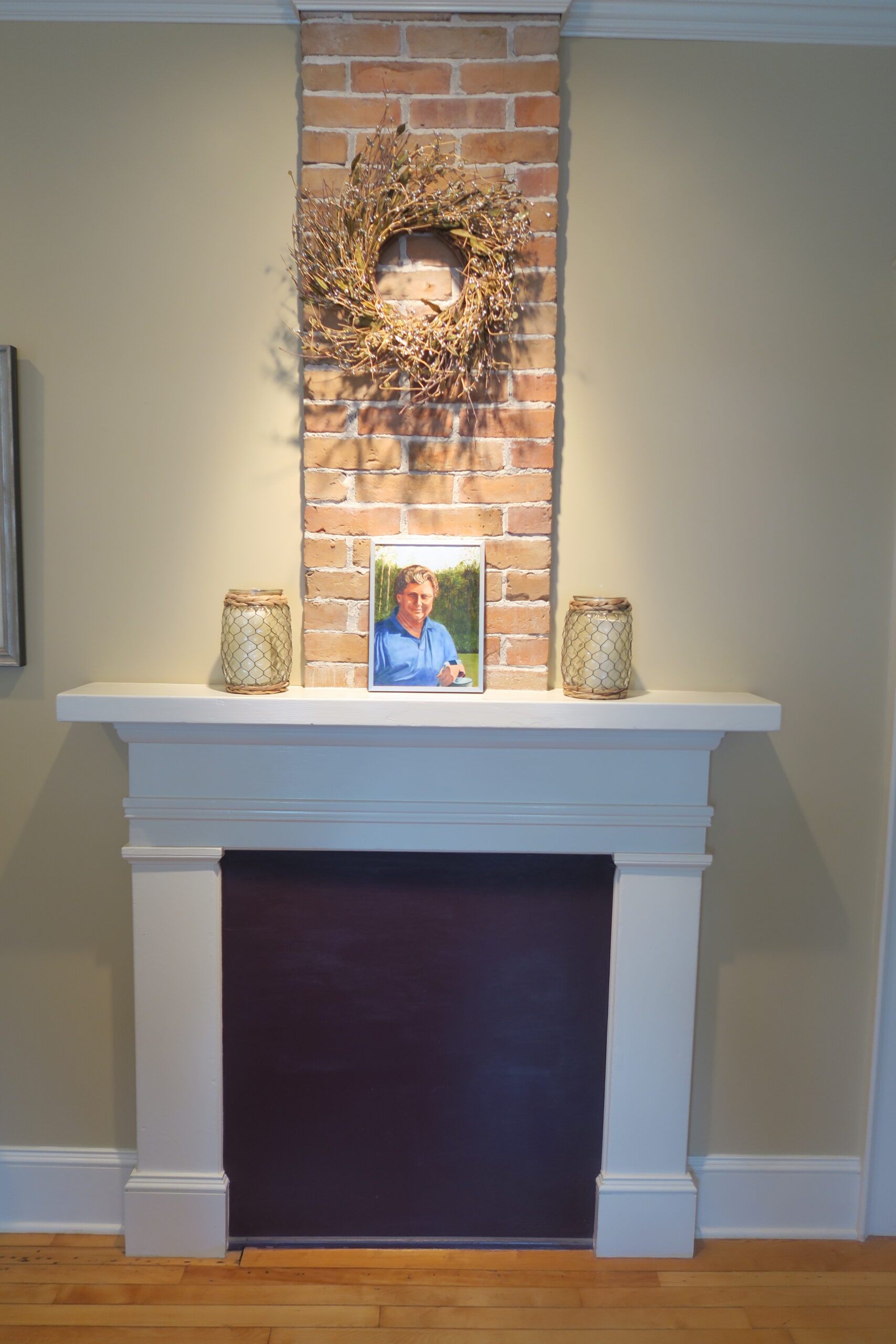 A fireplace inside Clayton's House with a painting of Clayton, the house's namesake.